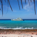 Areia branquinha, mar azul turquesa e o barco da Miss Ann Boat Trips ao fundo (Foto: Flymaniacs)